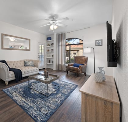 A living room with a white couch and a wooden coffee table.